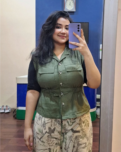 Kiara Beautiful Escorts in Indore taking a mirror selfie in a stylish green top and printed pants